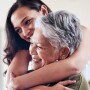 Adult daughter hugs elder mother