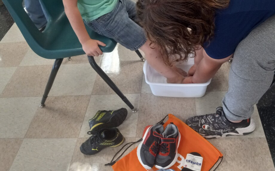 A child's feet are washed before he receives new socks and tennis shoes.