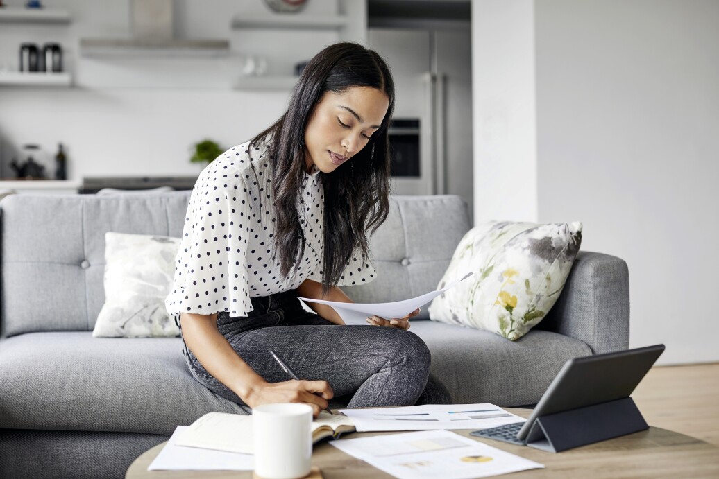Woman analyzing documents while sitting at home
