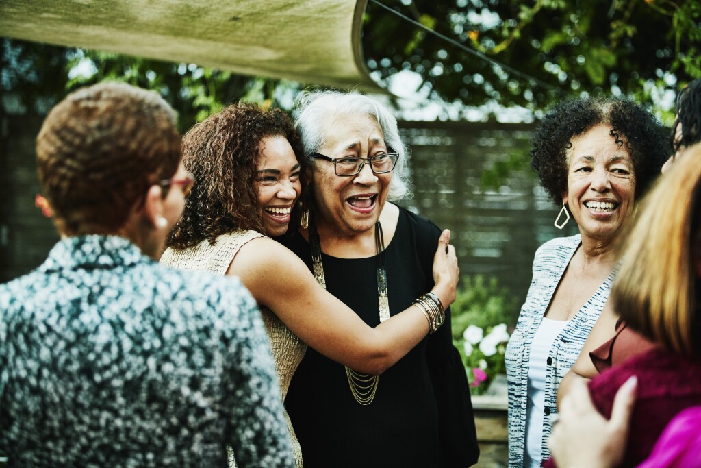 Daughter embracing senior mother after outdoor family dinner party