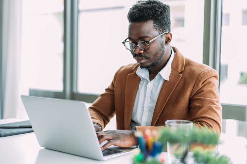 Businessman in modern office working on laptop.