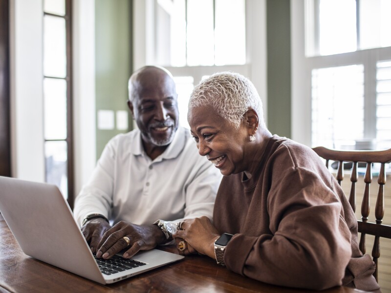 Senior couple using laptop at home