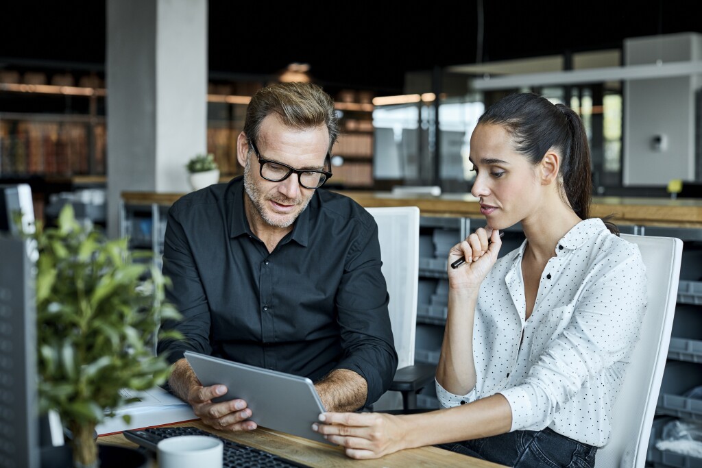 A man and woman looking at a laptop