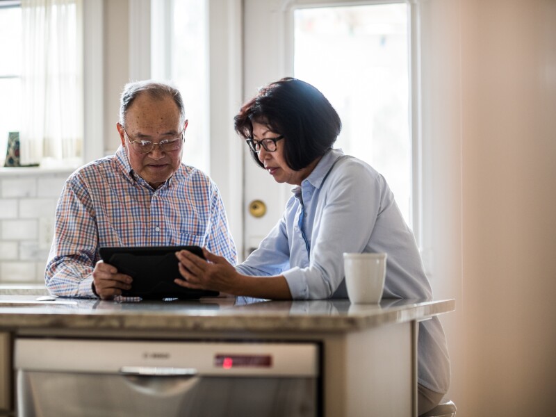 Senior couple using tablet on couch at home