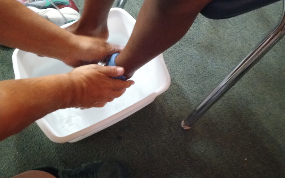 Before receiving new socks and tennis shoes, a volunteer washes the student's feet.