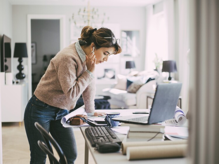 Woman standing by table working from home