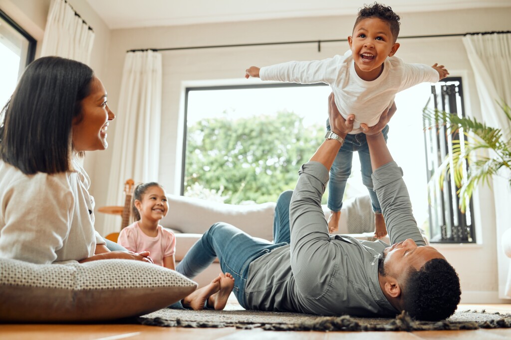Young family playing together on the lounge floor at home