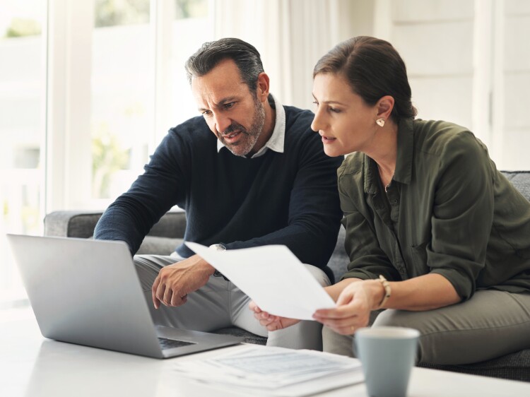 Two people on couch reviewing paperwork