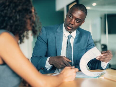 Man explaining paperwork to woman
