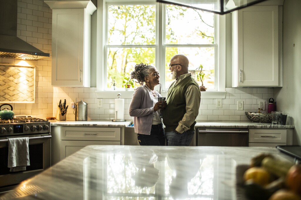 Couple embracing in kitchen of suburban home