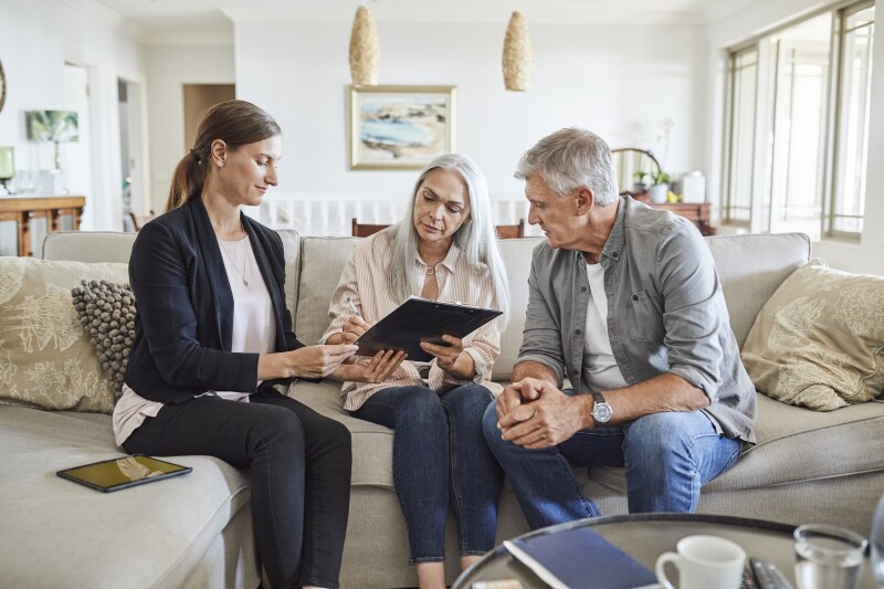 Mature couple with insurance agent at home