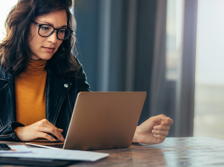 Asian business woman working on a laptop in a professional office