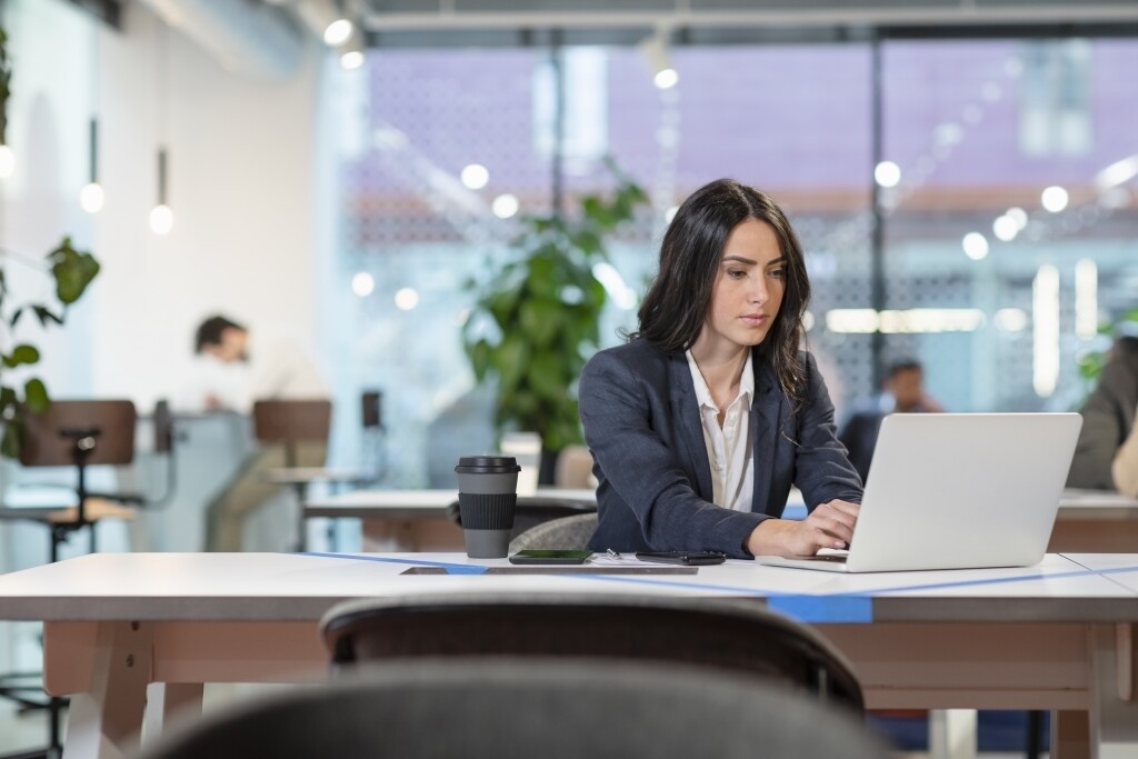 Businesswoman working on laptop at desk in office