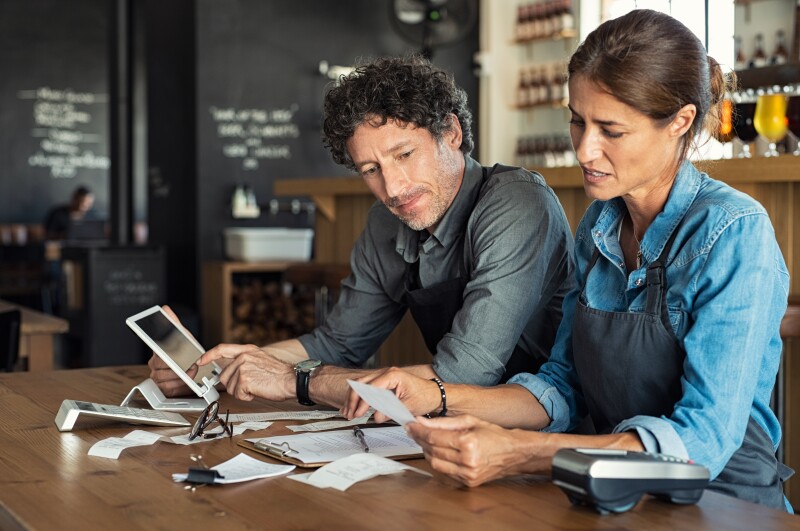 Small business owners reviewing papers and weighing options