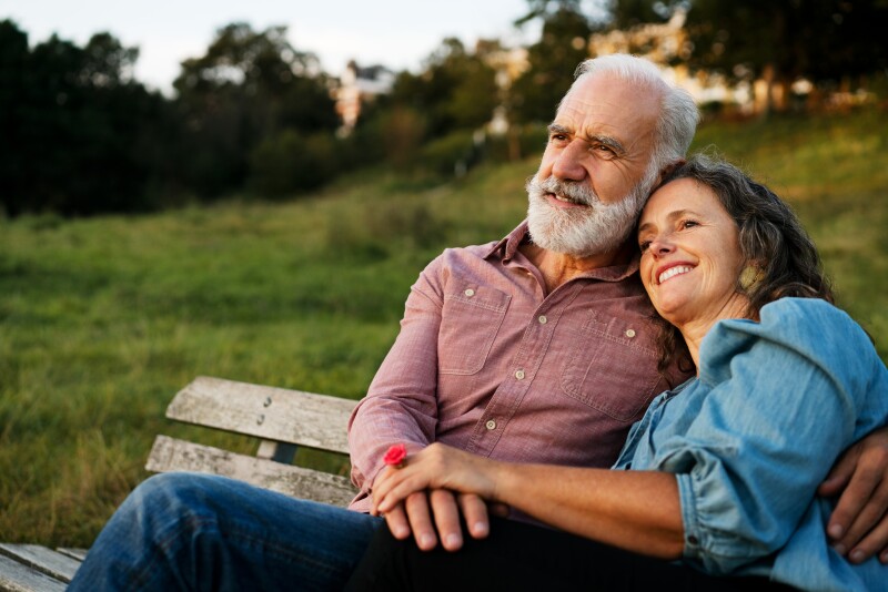 Man and woman on bench, holding hands