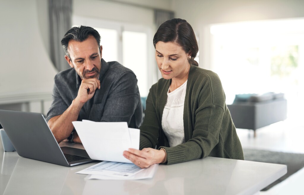 Couple paying bills at kitchen counter