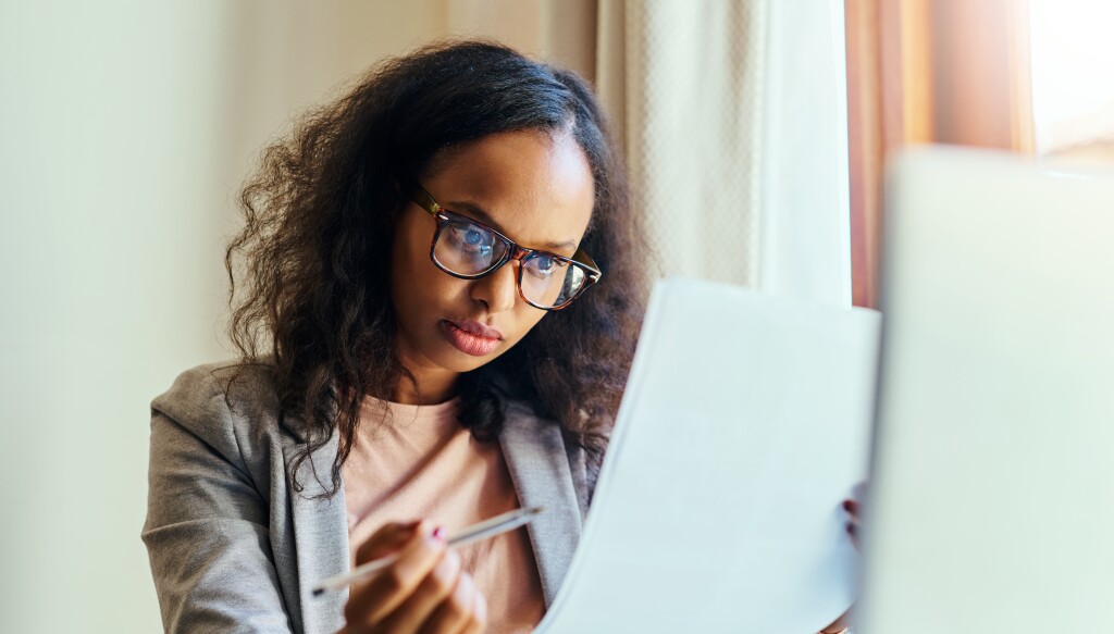 A young woman going through paperwork at home