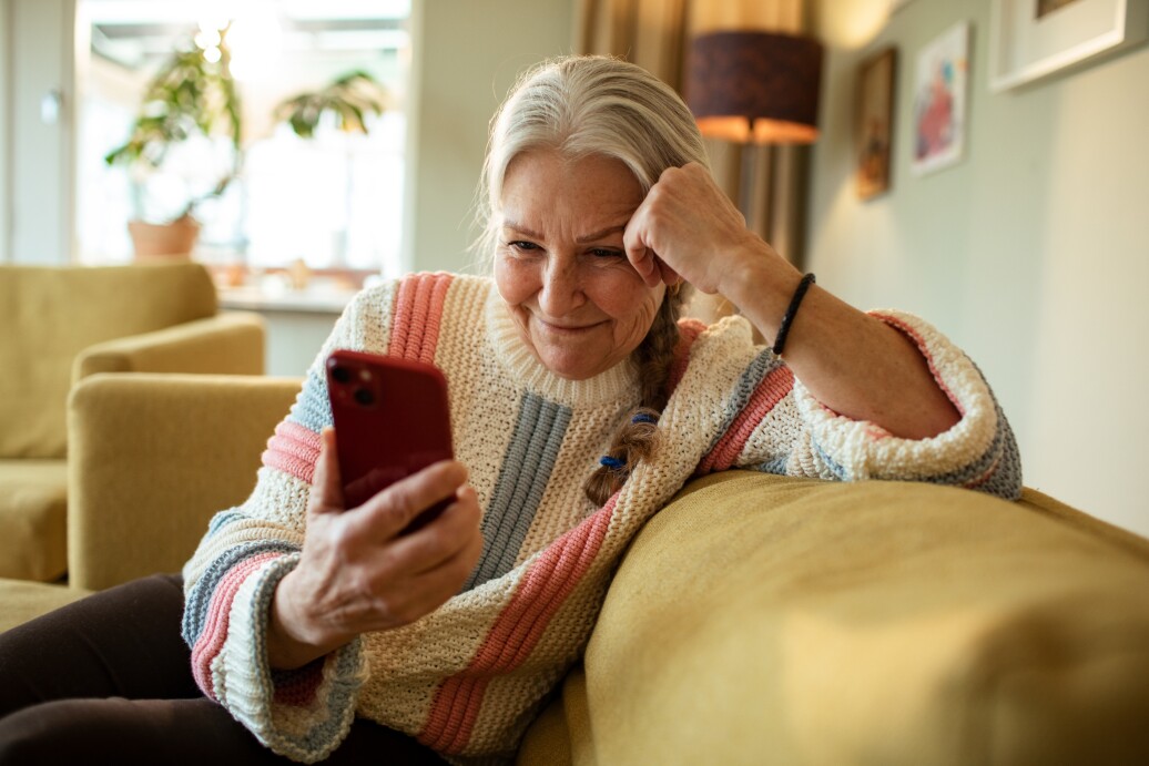 Senior woman using her phone on the couch
