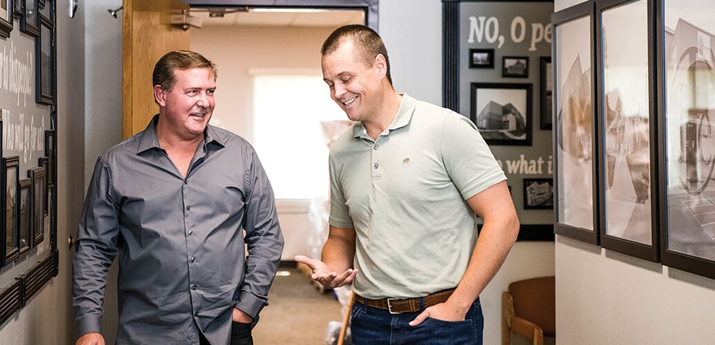 Two men talking in a hallway.