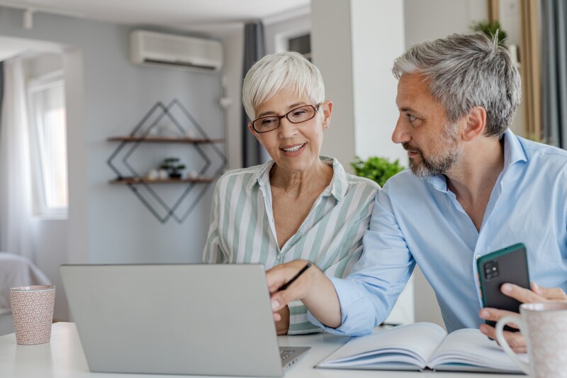 Mature couple at home using laptop together