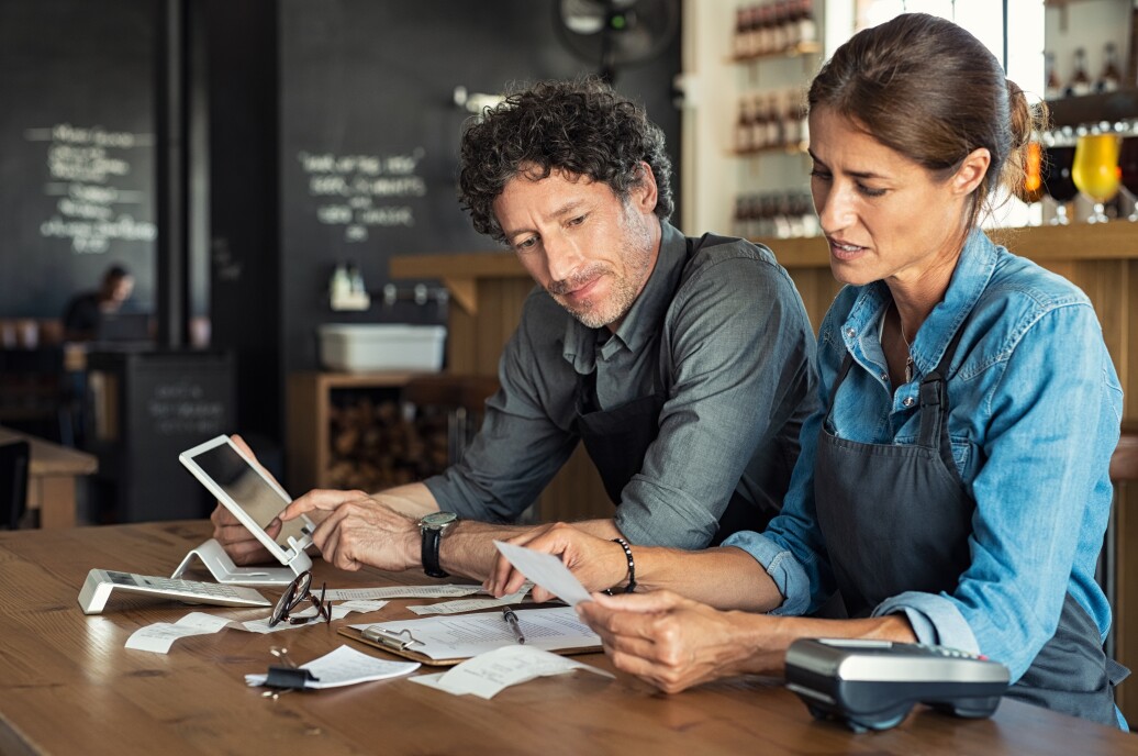 Small business owners reviewing papers and weighing options