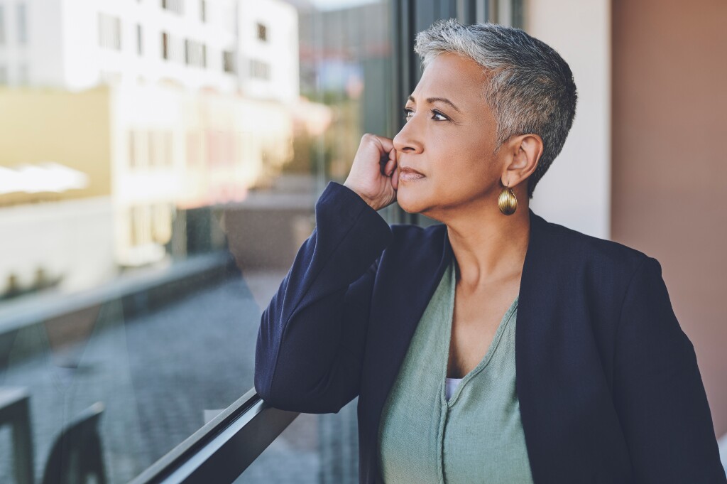 A woman in her late 50s looking out a window