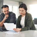 Couple paying bills at kitchen counter