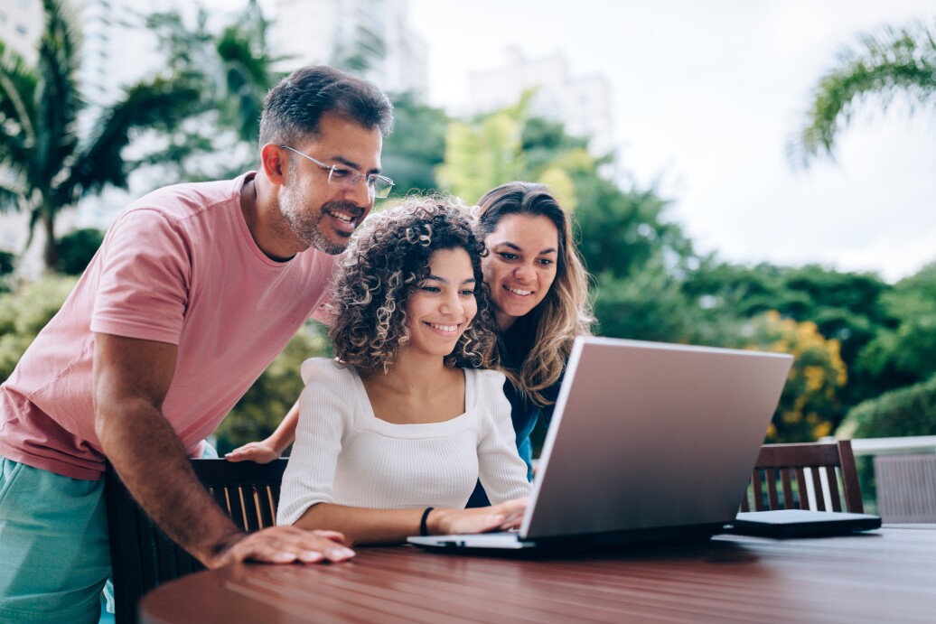 Family using laptop in the backyard