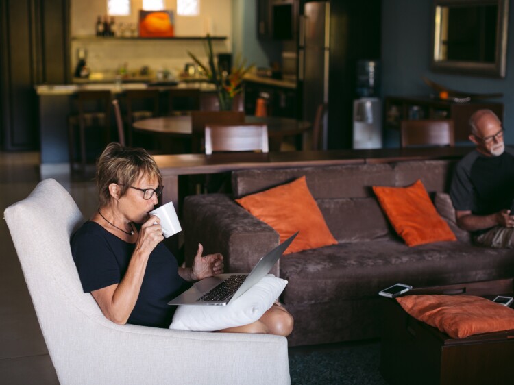 Woman on laptop drinking coffee.