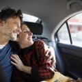 Smiling couple embracing while traveling in car