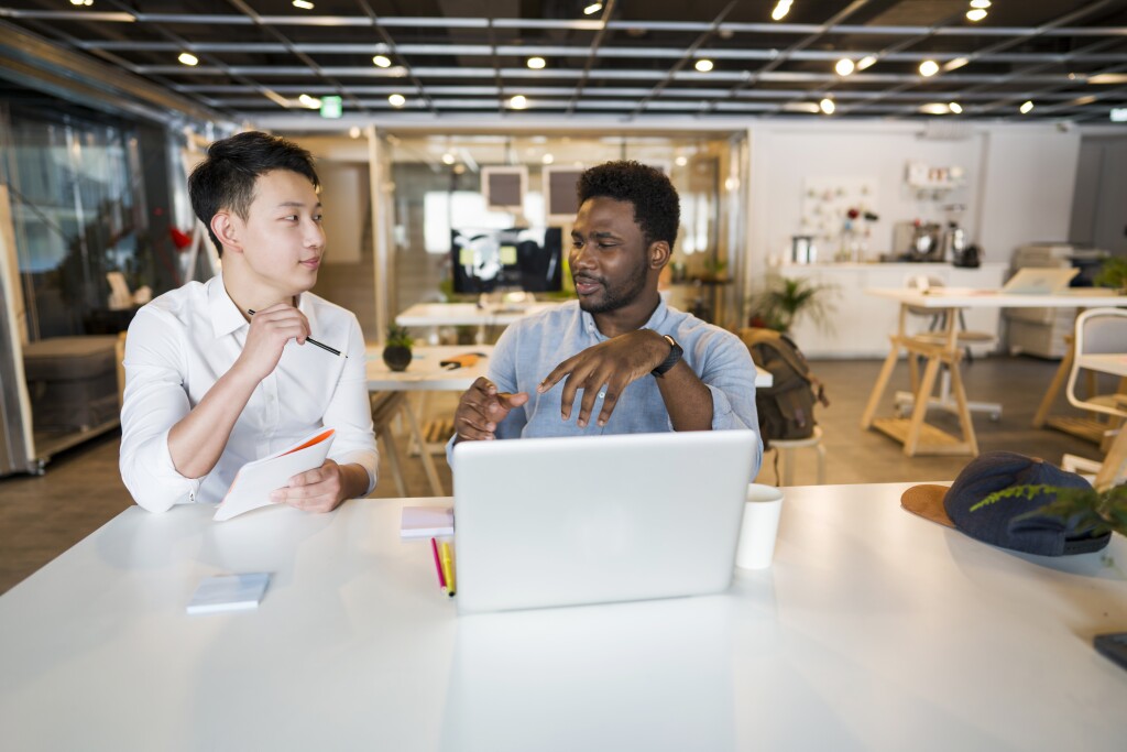 Two male colleagues working together at a computer.