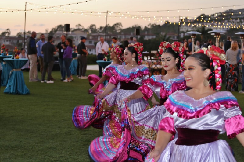 four women in spanish cultural outfits dancing