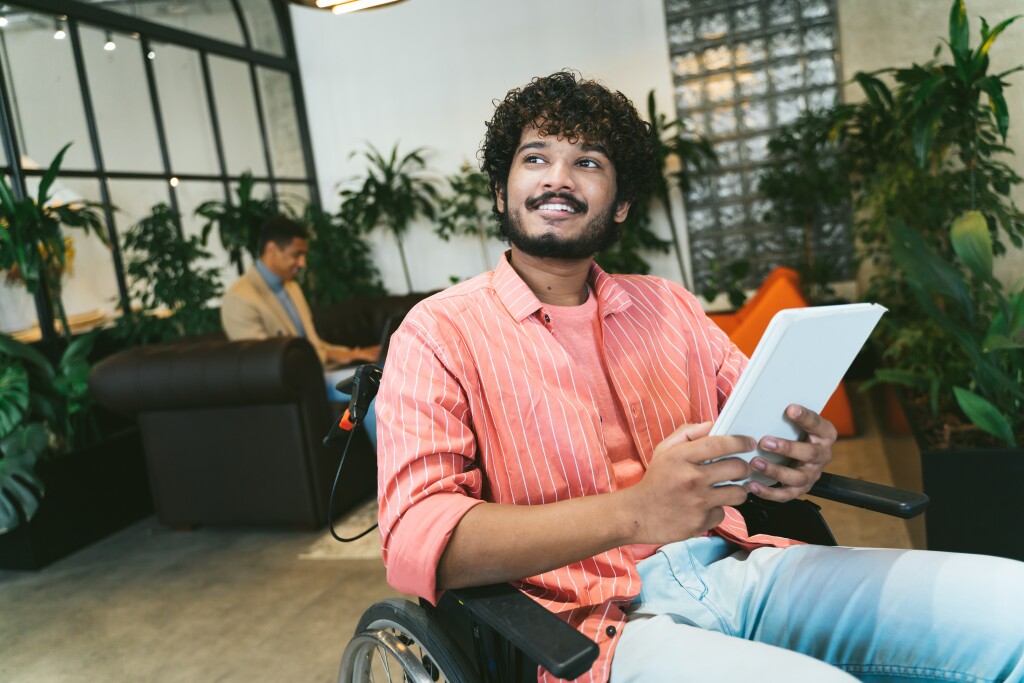 Smiling young man using tablet