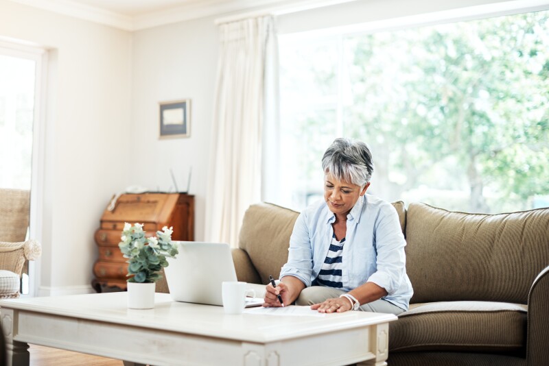 Shot of a woman doing paperwork at home