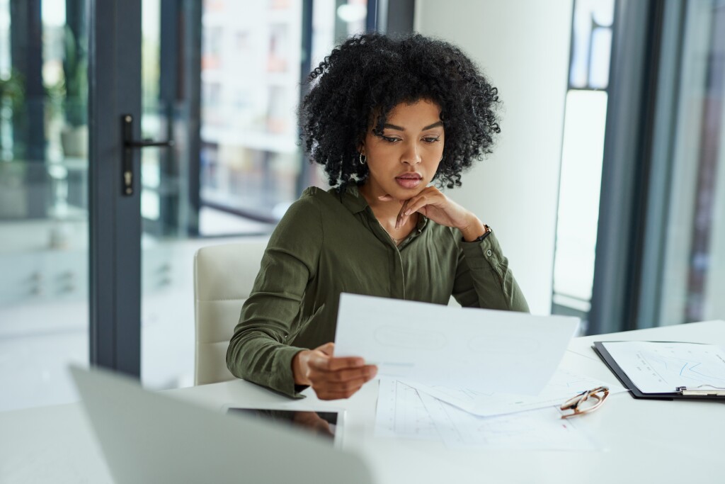 A businesswoman in her 30s going over paperwork in a modern office