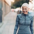 Senior woman walking with ear buds