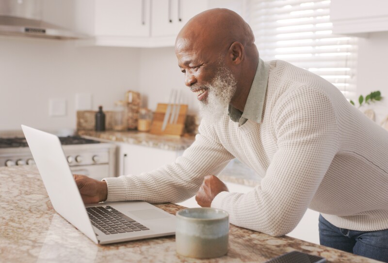Happy senior guy, computer and working in house