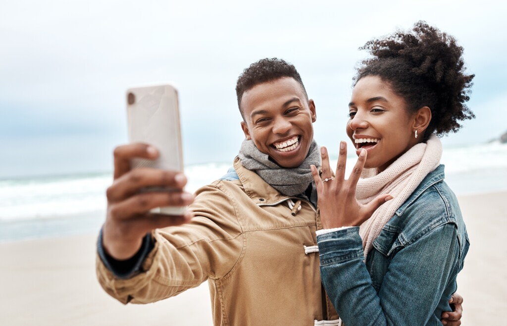 Cropped shot of a young couple taking a selfie at the beach