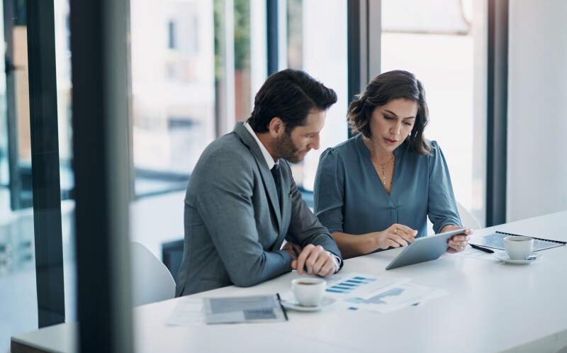 Two professionals meeting viewing tablet