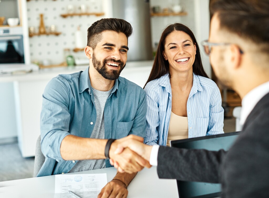 young couple shaking hands with financial advisor