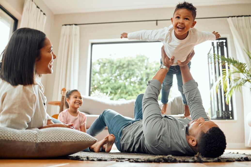 Young family playing together on the lounge floor at home