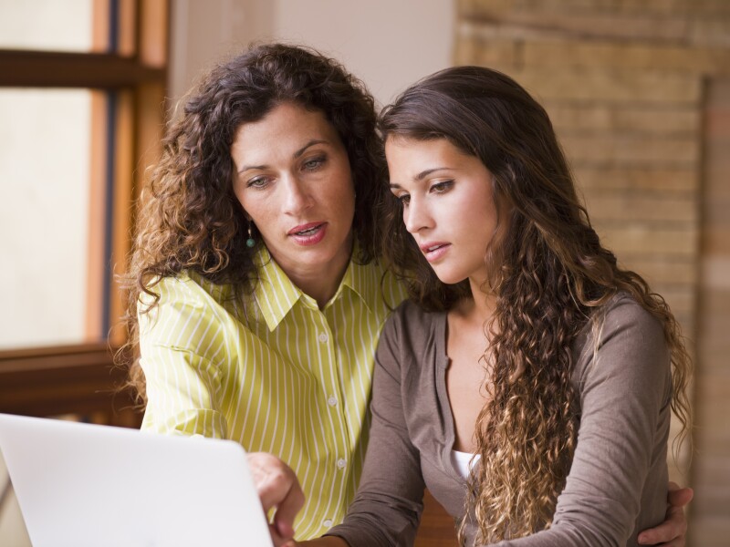 Mother and daughter looking at laptop