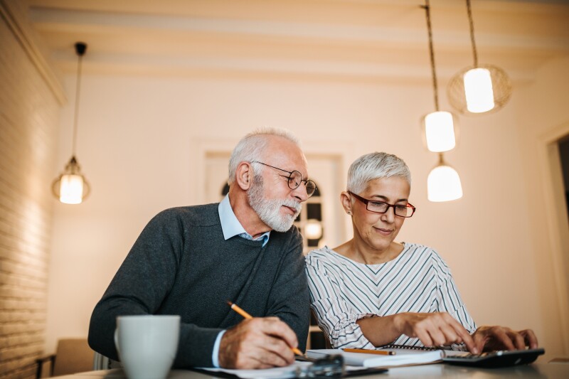 Mature couple doing some paperwork and calculations at home