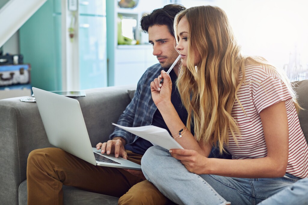 Photo of couple on couch looking at laptop