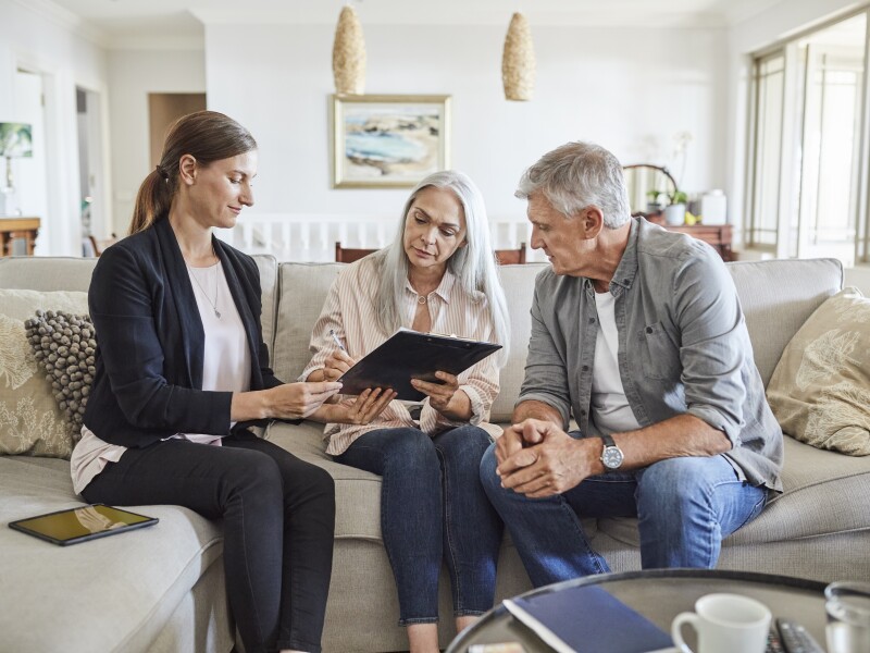 Mature couple with insurance agent at home