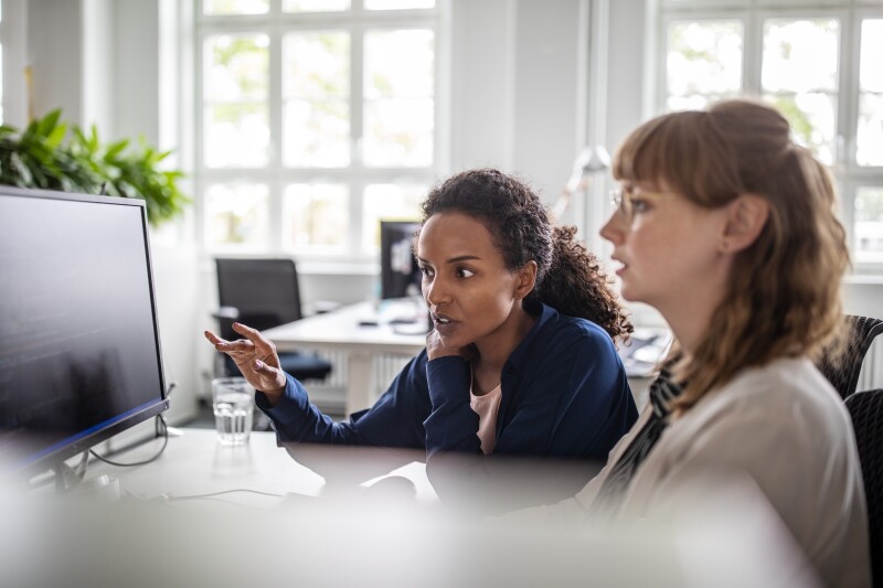 Businesswoman discussing taxes with coworker in office