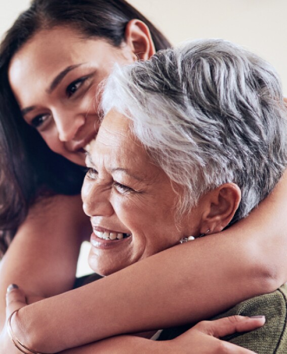 Adult daughter hugs elder mother