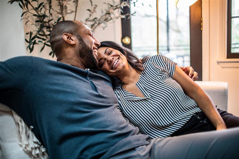 couple sitting on couch laughing